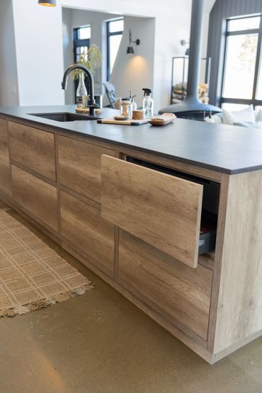 Close up of push to open oak cabinet doors along kitchen island