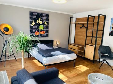 Bright modern bedroom with a Mickey Mouse artwork and stylish wooden furniture.