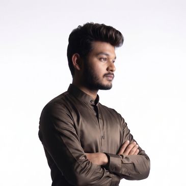 Young man with folded arms looking thoughtfully to the side.