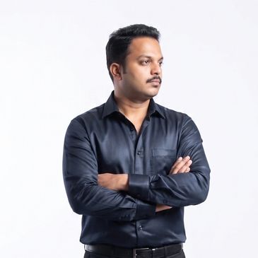 Man in black shirt standing with arms crossed against white background.