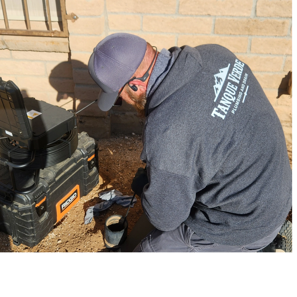 A plumber inspects a pipe with a camera from a RIDGID tool kit.