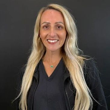 Smiling woman with long blonde hair against a black background.