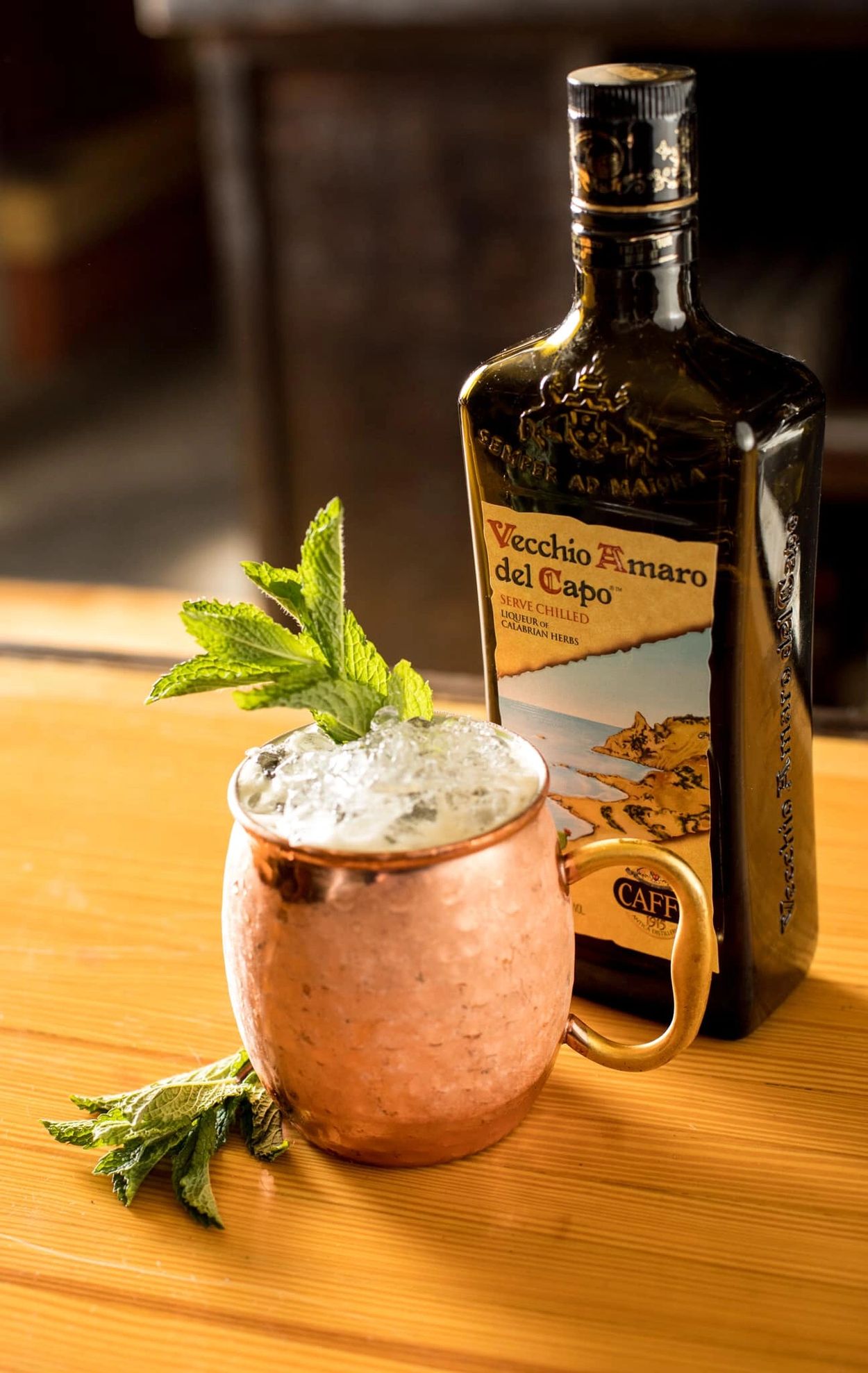 A scenic landscape featuring mountains, trees, and a clear blue sky.