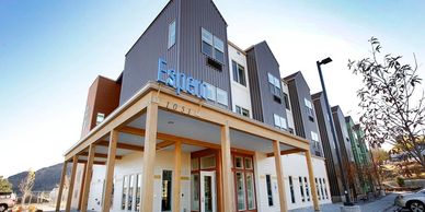 Exterior image of Espero, an apartment complex made of grey sheet metal siding and wood structures.