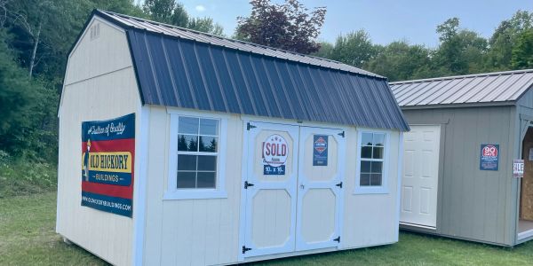 White shed with sold sign on the door.