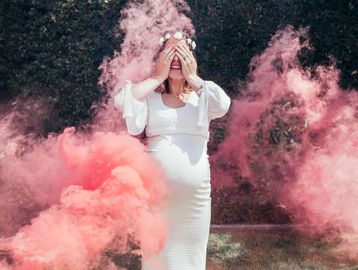 Pregnant mom gender reveal with pink smoke