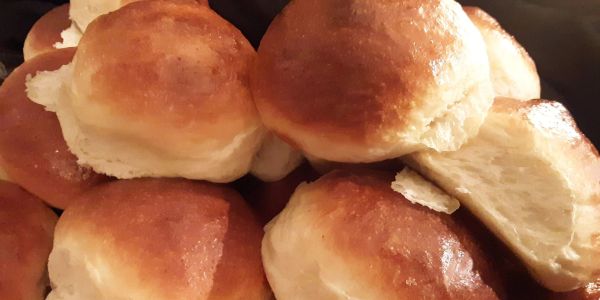 Close-up of golden brown dinner rolls with a soft texture.