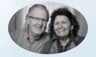 Black and white portrait of a smiling elderly couple in an oval frame.