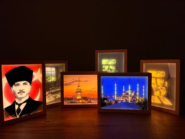 Illuminated frames showcasing Turkish landmarks and Atatürk's portrait in a dark room.