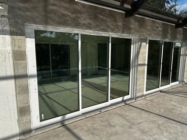 Two large sliding glass doors installed on a concrete wall.
