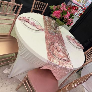 Elegant pink and white table setting with floral centerpiece and velvet napkins.
