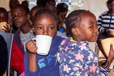February 24th Action - two young girls drinking porridge