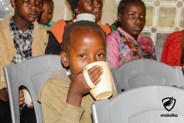 February 24th Action - a young boy drinking his porridge