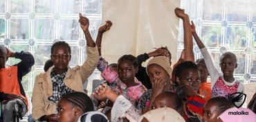 February 24th Action - children raising their hands during life skills session
