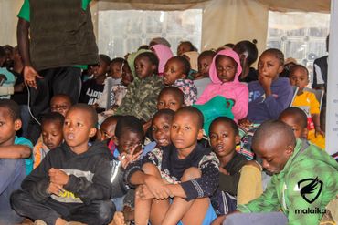 February 24th Action - children gathered under the tent some on the floor and some in chairs