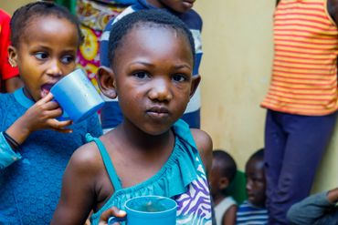 February 10th Action - two young girls with blue cups of porridge in their hands