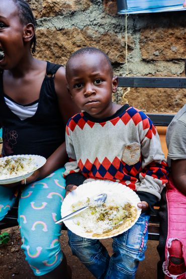 February 10th Action - Young boy with a bowl of rice, beans and salad in his hands