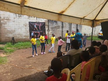 January 20th Action - young children most in yellow shirts standing up for a performance