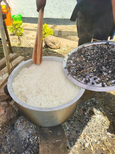 January 20th Action - Image of a large pot of cooked rice being stirred by a large wooden spoon.