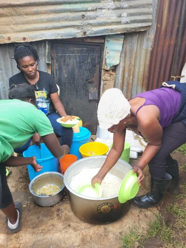 January 20th Action - Three women filling green bowls being with rice and beans from large pots