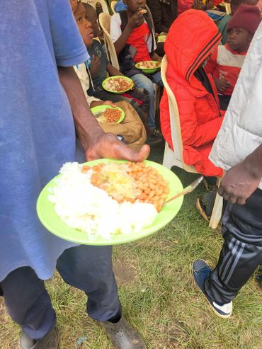 January 20th Action Rice, beans and salad on a green plate being held by a young man in a blue shirt