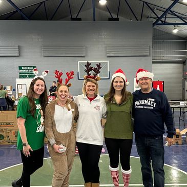 Group of people smiling together at a local service event.