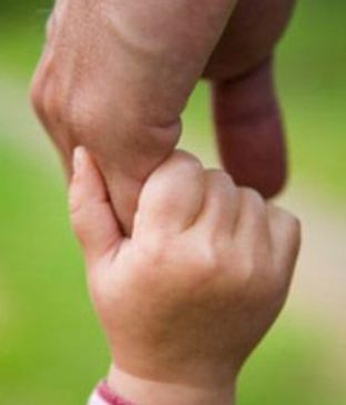 Adult hand holding a child's hand