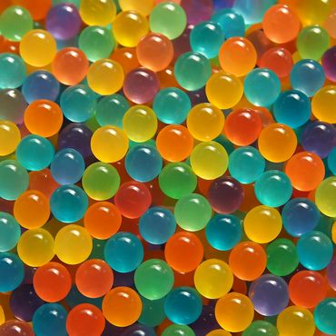 Colorful translucent water beads closely packed together.