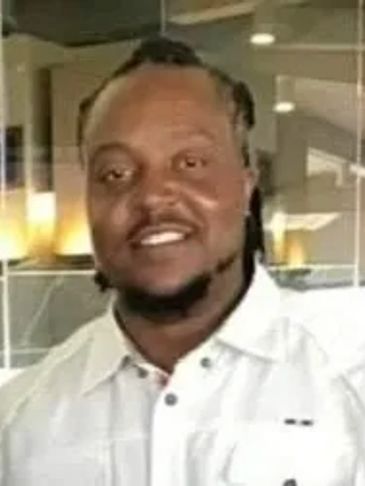 Smiling man in white shirt indoors.