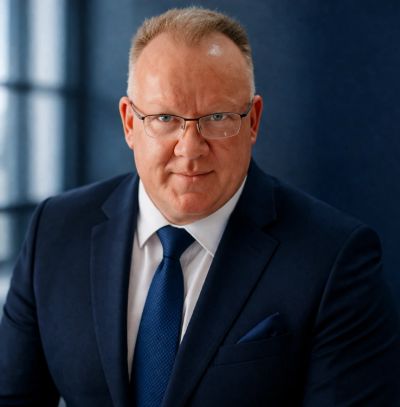 Confident middle-aged man in a suit and glasses.