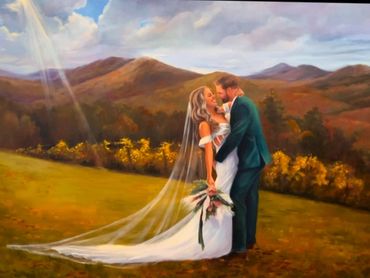 A bride and groom share a romantic kiss with mountains in the background.
