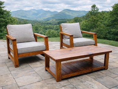 Outdoor wooden chairs and table on a patio with mountain view.