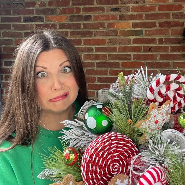 Phot of designer making a silly face while holding one of her designs.