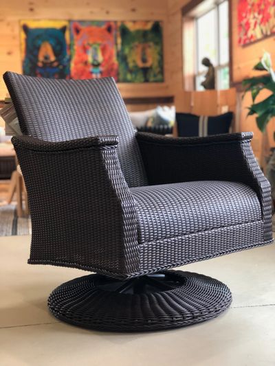Dark brown wicker chair in foreground with blurred out picture in background.