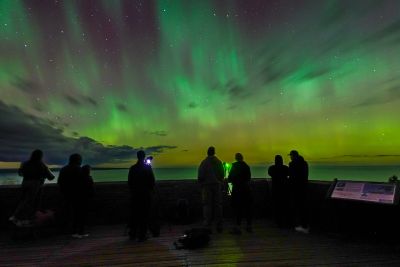 People watch the northern lights at night.