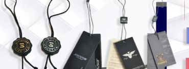 Various clothing tags and labels displayed on a white surface.