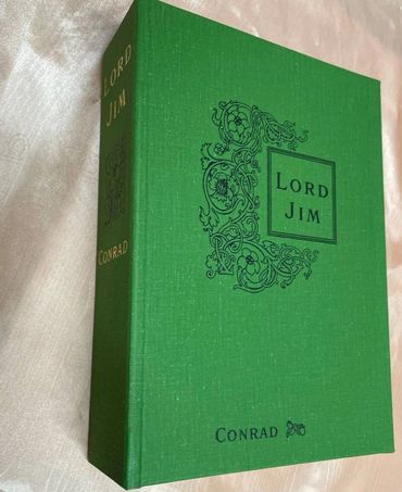 A custom clamshell box with a cloth finish and decorative foil stamping for premium book protection.
