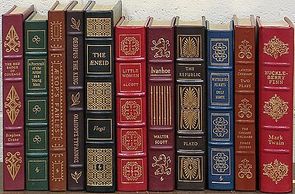A neatly arranged row of classic, leather-bound books displayed on a shelf.