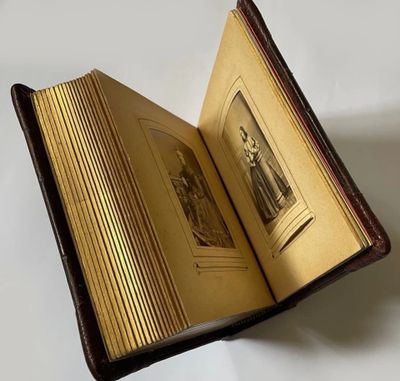 Antique photo album with gilt-edged pages and leather cover