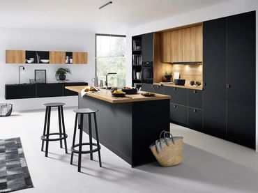 Modern kitchen with black and wood cabinetry and a central island with stools.