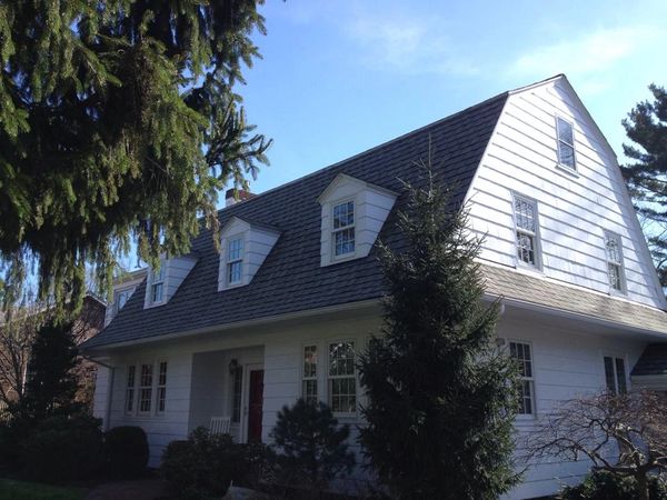 A Roofing Project.  A white house with a dark grey shingle