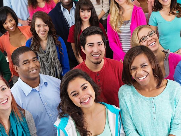 A diverse group of smiling young adults posing together.