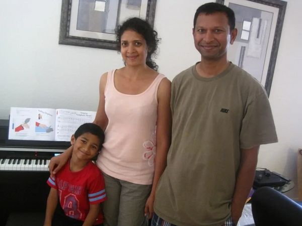 Family playing music on a digital piano