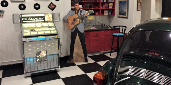Elvis Presley standing next to jukebox