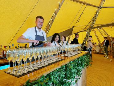 Pallet bar at tipi wedding with faux ivy, serving prosecco arrival / welcome drinks