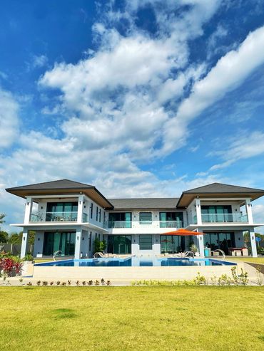 Modern two-story house with pool and clear blue sky.