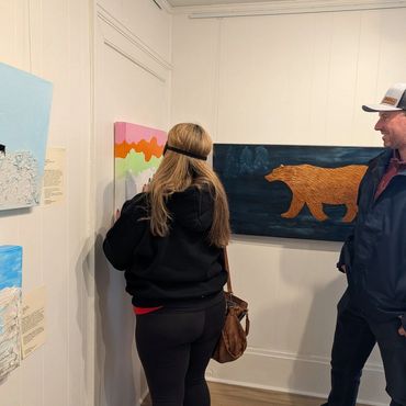 Two people at the exhibit feeling the art.