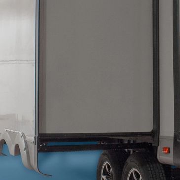 Close-up of back tires on a white truck with gray panel.