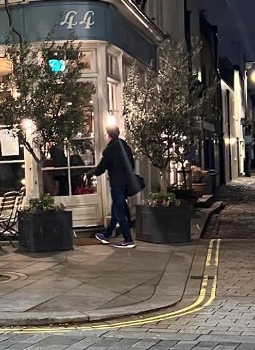 Night view of The Thomas Cubitt pub with outdoor seating and festive lights.