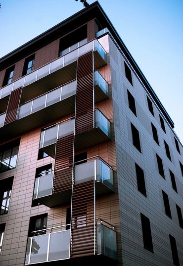 Modern apartment building with glass balconies and sleek design.